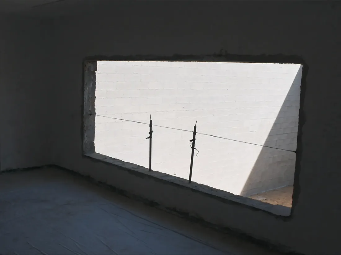 A new opening formed through an existing blockwork wall with adjustable steel props carrying the floor above